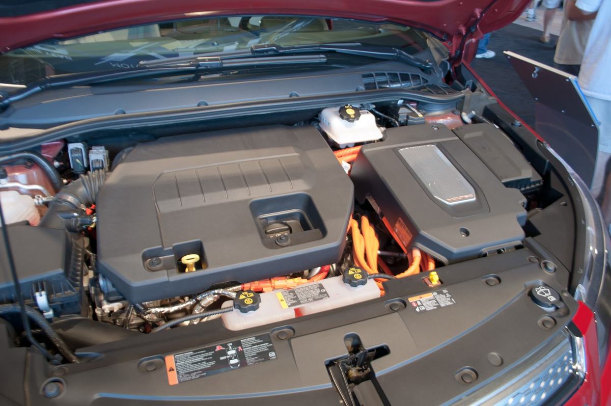 Open hybrid engine bay with service components and high-voltage cables
